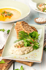 Several dishes of pumpkin soup, salad and sandwich