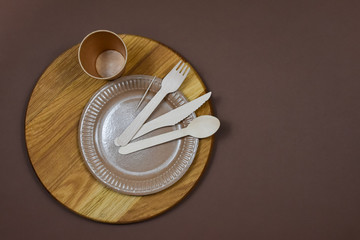 Zero waste, environmentally friendly, disposable, cardboard, paper utensils on a brown background. View from the top. Place for an inscription. View from above.