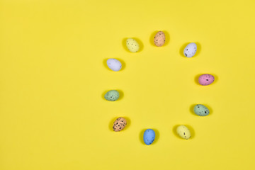 Easter eggs laid out in a circle on a yellow background. View from above. The basis for the postcard. Place for an inscription. Easter concept.