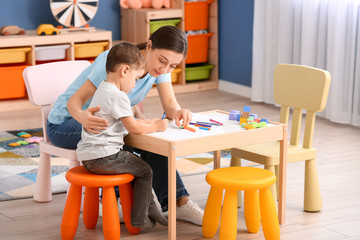 Nanny and cute little boy drawing at home - obrazy, fototapety, plakaty