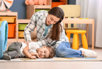 Nanny and cute little boy playing at home