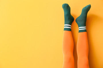 Legs of young woman in socks and tights on color background