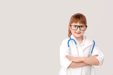 Cute little doctor on grey background