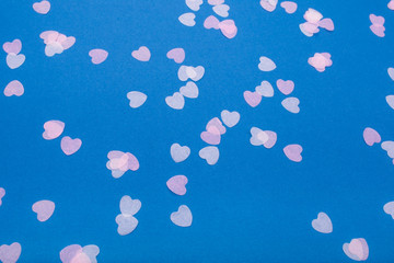 Fototapeta na wymiar Confetti hearts on a blue background. Flat lay, copy space, top view. Holiday concept.