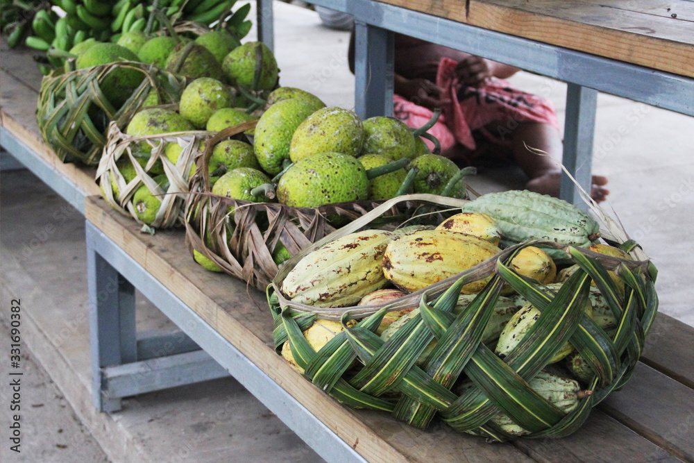 Wall mural Samoan using coconut leaves to weave a basket for carrying the agricultural product.