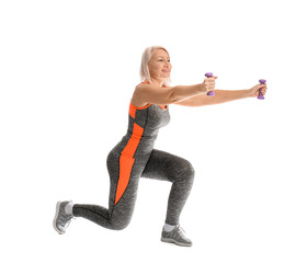 Sporty mature woman doing exercise with dumbbells on white background