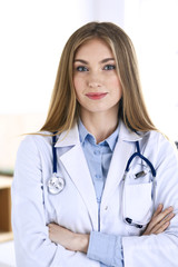 Woman doctor standing in hospital office. Physician at work, life portrait. Medicine and health care concept