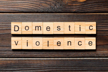 Domestic violence word written on wood block. Domestic violence text on wooden table for your...