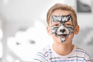 Funny little boy with face painting at home