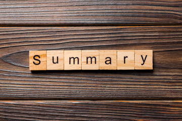 Summary word written on wood block. Summary text on table, concept