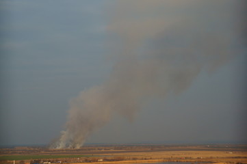 Fototapeta na wymiar Smoke from a fire in a field area.