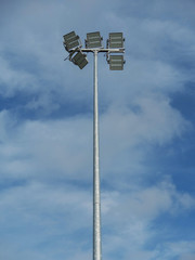 Modern LED lights on a poles against a cloudy blue background.