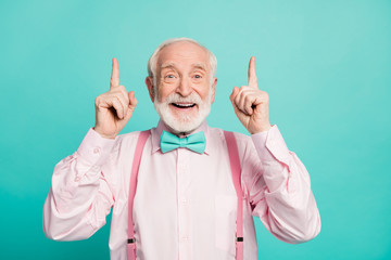 Portrait of amazed excited old man point index finger up recommend suggest select ads promo sales wear pink shirt bowtie isolated over turquoise color background