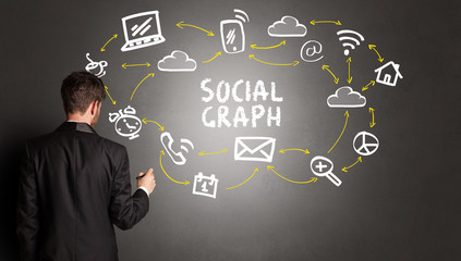 businessman drawing social media icons with SOCIAL GRAPH inscription, new media concept