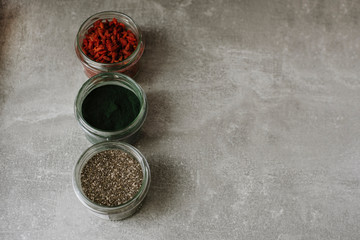 Superfoods in glass jar on grey background. Concept of healthy food products.