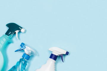 Productos de limpieza: botella, pulverizador, detergente sobre fondo celeste liso aislado. Vista...