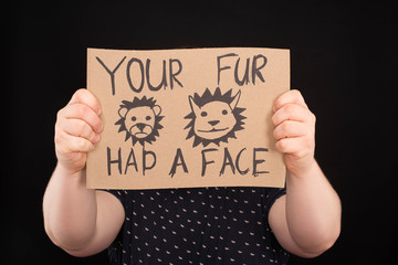 Obraz premium man with obscure face holding sign with your fur had a face inscription isolated on black