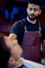 Portret Young hairdresser at his hairdresser. a man with a beard.