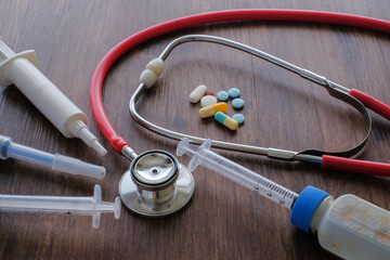 Medical background from pharmaceutical tablets and pills, stethoscope, heart and syringe. ...