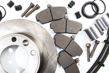 brake parts on white: brake pads, disc, brake hose, guides, cylinders .