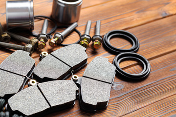 brake parts on wooden background  brake pads, disc, brake hose, guides, cylinders- Image