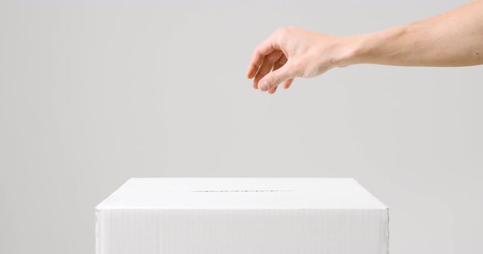 Hand casting vote into the ballot box at elections. Voting and elections concept.