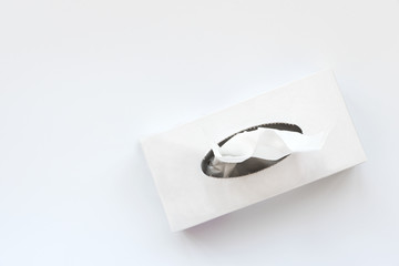Picking facial napkin/tissue paper from the tissue box on white background. Top view. Flu, illness,...