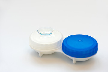 Contact lens on contact lens case on white background. Soft focus. Macro. Ophthalmology and health concept