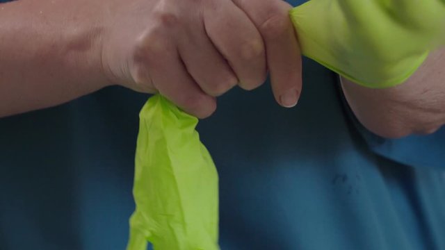 Person putting on a pair of disposable gloves