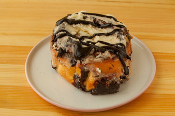 roll with cinnamon on a plate on  wooden background