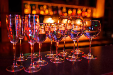 Many wine glasses on the bar with brilliance and light