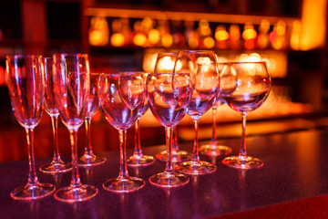 Many wine glasses on the bar with brilliance and light