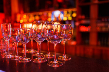 Many wine glasses on the bar with brilliance and light