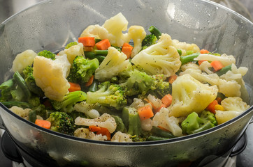 Raw vegetables are steamed in a double boiler