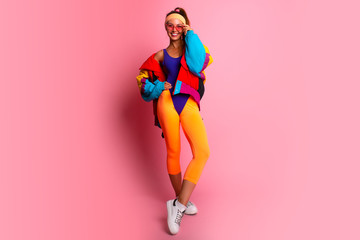 Full length image of 80's Fashion woman over pink background. Beautiful athletic girl in 80s style...