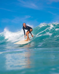 Female surfer on a blue wave