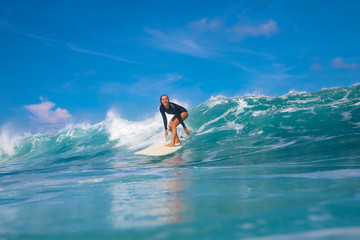 Female surfer on a blue wave