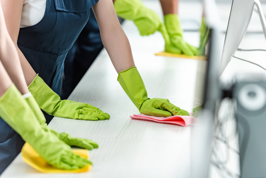 Cropped View Of Cleaners In Rubber Gloves Cleaning Office Desk