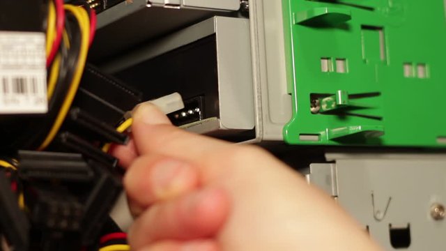 female hands unhooking the dvd player connector of a desktop pc
