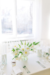  Light decor in the style of fine art. Glasses and tulips in the composition. Wedding table decor with white Studio.