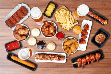Composition of fried Fast food Snacks, sausage,french fries and beer