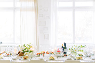 Light decor in the style of fine art. Glasses and tulips in the composition. Table setting for a feast. Wedding table decor in the white Studio.