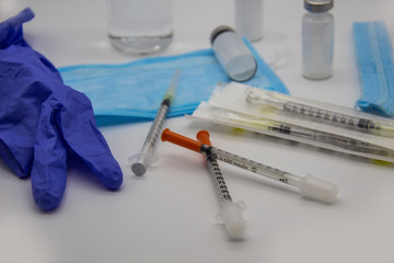 The bottles of insulin for diabetes and injection syringe. The healthcare concept with syringes against background. On the table are medical items and injection syringes.