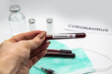 Coronavirus blood test 2019-2020. Female hand holding test tubes with blood in laboratory. Concept can be used in the design