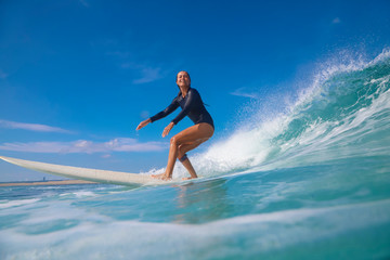 Female surfer on a blue wave