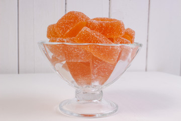 orange marmalade in a candy bowl on a white background