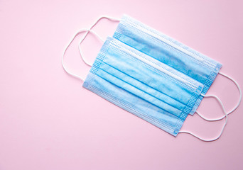 Fototapeta premium Two blue medical masks lie on a yellow, blue and pink background. Place for text. Copy Space. COVID-19