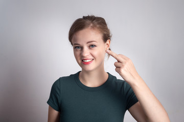 Young caucasian woman smiles, shows middle finger