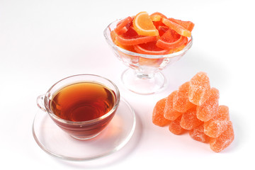 a Cup of tea and citrus marmalade in a candy bowl on a white background