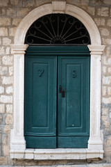 Closed vintage blue doors with an arch above them